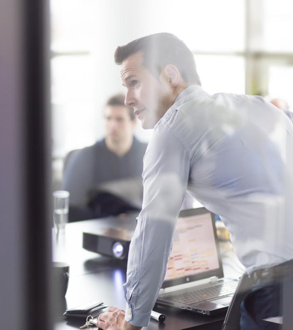 Image of a man in an office with a laptop