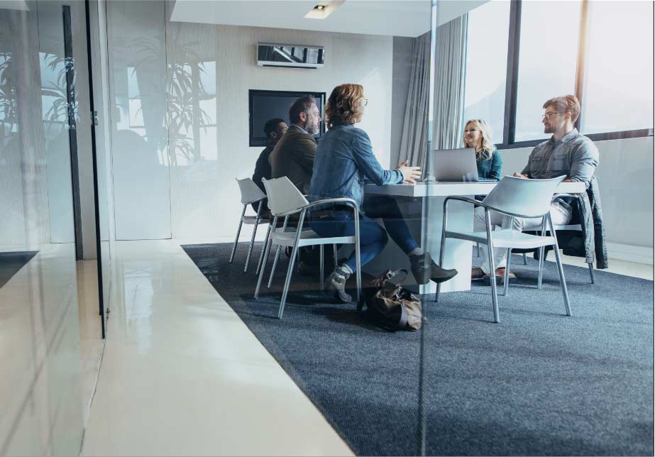 group of office workers sitting at a meeting table