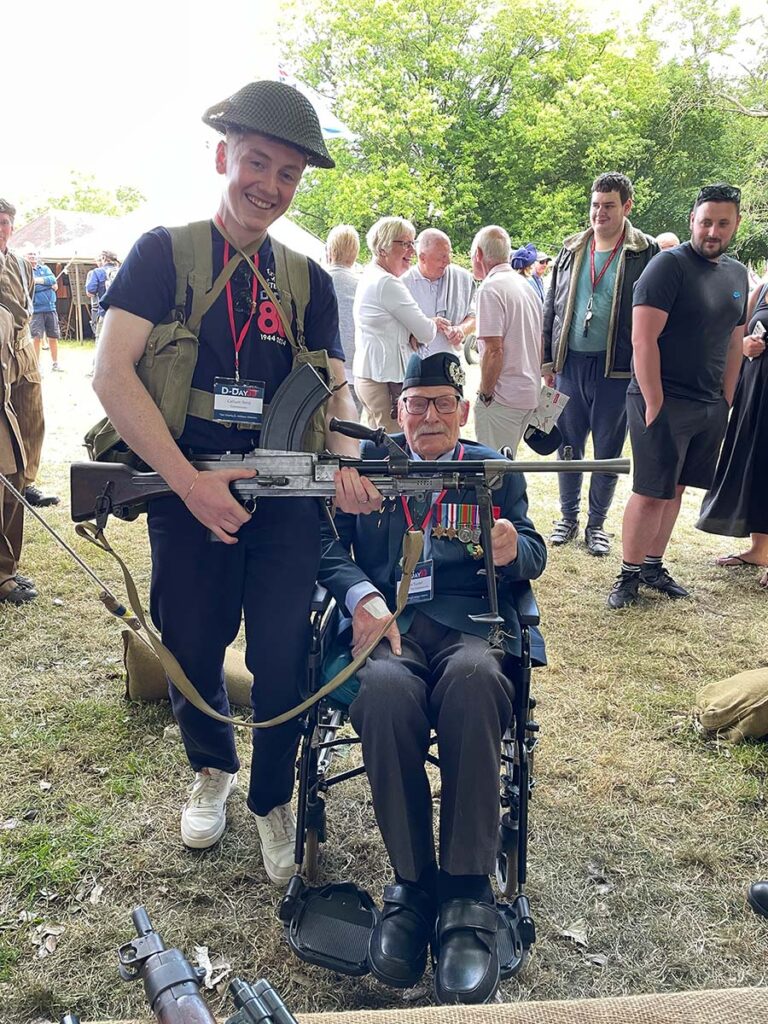 Callum Reid wearing a helmet and holding a gun, with Donald Turrell